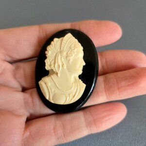 Vintage plastic oval cameo brooch with woman profile.